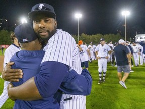Roop Chanderdat, co-owner and manager of the London Majors, gets a big hug from slugger Cleveland Brownlee after the club won its first Intercounty Baseball League title since 1975 with an 8-4 victory in the winner-take-all Game 5 against Toronto on Oct. 1, 2021, at Labatt Park. (Mike Hensen/The London Free Press)
