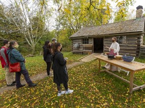 Jennifer Summers, a staff member at the Fanshawe Pioneer Village, was displaying how apple crumble would have been made in a Dutch oven in years gone by. The Poole family is  taking in the lesson.
Photograph taken on Sunday October 10, 2021.  (Mike Hensen/The London Free Press)