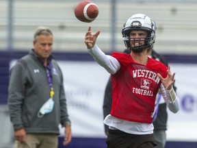 Under the close eye of head coach Greg Marshall, quarterback Evan Hillock slings a pass out to the flats during a Western Mustangs practice. (Mike Hensen/The London Free Press)