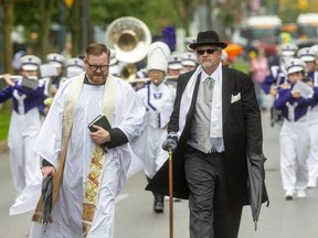 Capt. Rev. Quenton Little, an Anglican padre in the Canadian Forces, and funeral director Joe O’Neil lead the Western University marching band as they head along Wellington Street near Dufferin Avenue as part of the funeral for London’s unofficial town crier Bill Paul, who died Sunday at age 66. The procession honoured the funeral tradition of passing by the home of the deceased on the way to the place of burial. In this case, it circled Victoria Park, which was considered Paul’s home for the countless events he attended there. Participants were encouraged to make noise and dance. London realtor George Georgopoulos even let off a firework on Dufferin as the hearse passed by. (MIKE HENSEN, The London Free Press)