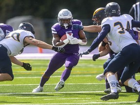 Western Mustangs running back Keon Edwards runs through holes created by his offensive line against Windsor during their OUA football game on Saturday October 16, 2021 at Alumni Stadium. Mike Hensen/The London Free Press