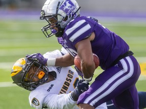Western Mustangs slotback Savaughn Magnate-Jones tries to push off the tackle of Windsor's Clayton Shreve, but Shreve held on for the tackle during their OUA football game on Oct. 16, 2021 at Alumni Stadium. Mike Hensen/The London Free Press/Postmedia Network