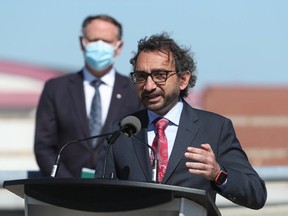 Transport Minister Omar Alghabra speaks while Ottawa South MP David McGuinty looks on during a press conference at the Ottawa MacDonald-Cartier International Airport on Wednesday, June 16, 2021.