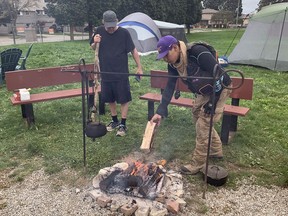 Protesters from Six Nations of the Grand River tend to a fire Tuesday inside the gates of the former Arrowdale municipal golf course in Brantford. They moved onto the property on Saturday in opposition to the city's planned sale of the land.