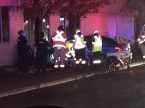 Emergency personnel stand near a vehicle that crashed early Friday morning at York and Glebe streets in London. The female driver suffered serious injuries, London police said.  (Twitter photo)