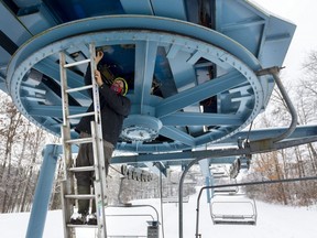 Shaun Bonnallie, outdoors operations manager for Boler Mountain, inspects a mechanical roll-back protection system installed on the giant pulley that drives the cable used in the ski hill's chairlift. Although the white stuff looks pretty, Boler isn't ready to welcome Southwestern Ontario enthusiasts anytime soon. Bonnallie said it needs a good cold snap to make enough snow to form a solid base on its runs. (Mike Hensen/The London Free Press)