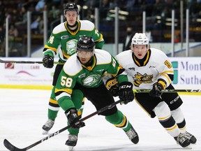 London Knights player Bryce Montgomery, left, checks Sarnia Sting rival Nolan Dann in the first period at Progressive Auto Sales Arena in Sarnia on Tuesday, Nov. 16, 2021. The Sting won, 4-2. Mark Malone/Chatham Daily News/Postmedia Network