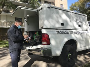 An investigator from the Ontario Fire's Marshal Office is shown at the scene of a suspicious fire on Adelaide Street North in London. A 29-year-old man is been charged with arson, police said Wednesday.  (London fire department photo)