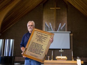 Mike Lee holds one of two memorial plaques for veterans of the First and Second world wars that hung at Fairmont United Church on Tweedsmuir Avenue in London before it closed. (Derek Ruttan/The London Free Press)