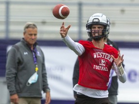 As head coach Greg Marshall watches, quarterback Evan Hillock slings a pass during a Western Mustangs practice. Hillock, an elite-level pitcher in high school, will finish his first season with the Mustangs as their starting quarterback in the Vanier Cup on Saturday when they take on the Saskatchewan Huskies in Quebec City.  (Mike Hensen/The London Free Press)