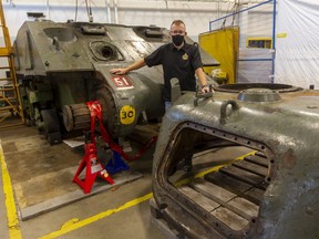 Volunteer restoration team leader Gary Cambridge stands between Holy Roller's hull and its gunless turret as the iconic Second World War  tank undergoes extensive restoration at Fanshawe College  in London. (Mike Hensen/The London Free Press)