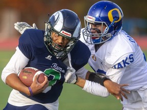 Laurier quarterback Damon Barrow gets tackled by Jackson MacKay of Oakridge as he takes it himself during their quarterfinal matchup Wednesday at City Wide Field. The Rams were not to be denied and won 42-3 over the Oaks. (Mike Hensen/The London Free  Press)