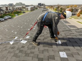 After a two-year wait, work has begun to put solar panels on the remaining townhouses in Sifton's West 5 community in London. Curtis Visser of German Solar in London secures anchors into the roof of a townhouse, one of 13 buildings where solar panels will be installed. After the anchors, come rails to which the solar panels will be secured. Mike Hensen/The London Free Press