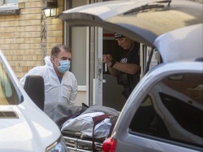 The body of John Flores, 39, is taken from an apartment building at 69 Cartwright St. on Nov. 10. Kenneth Cardiff, 42, of London is charged with second-degree murder. London police have investigated 13 homicides to date in 2021. (MIKE HENSEN, The London Free Press)