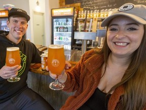 Aaron Hendrikx, owner of BackRoad Brews and Shoes and Emma Maganja, marketing manager at London Brewing Co., enjoy a new beer called Runner's High, a dry hopped pale ale on Wednesday, Nov. 17, 2021. (Mike Hensen/The London Free Press)