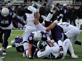 Players wind up in a heap during a play in the fourth quarter of the Mitchell Bowl at Western Alumni Stadium in London on Saturday, Nov. 27, 2021. The Western Mustangs beat St. Francis Xavier X-Men 61-6 to advance to the national university football championship, the Vanier Cup. DALE CARRUTHERS/THE LONDON FREE PRESS