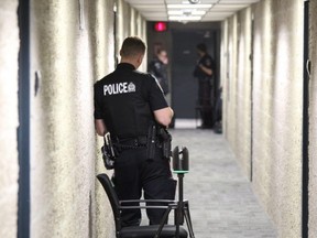 Several London police officers were stationed on the 12th floor of an apartment building at 205 Oxford St., where a man was critically injured in a stabbing Monday morning. (DALE CARRUTHERS, The London Free Press)