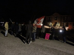 About 50 people gathered in front of what they said is Sarnia-Lambton medical officer of health Dr. Sudit Ranade's home Tuesday evening to protest COVID-19 vaccine and masking requirements. (Tyler Kula/The Observer)