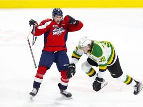 London Knights player Max McCue gets the worst of a collision with Nathan Ribau of the Windsor Spitfires during the first period of their OHL hockey game at Budweiser Gardens in London on Friday, Dec. 10, 2021.  (Derek Ruttan/The London Free Press)