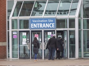 People enter the COVID-19 mass vaccination clinic at the Western Fair District Agriplex. The Middlesex-London Health Unit reported nearly 900 new COVID-19 cases Monday since its last update Dec. 24. Photograph shot Dec. 22, 2021. (Derek Ruttan/The London Free Press)