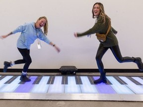 Ange Rivard and Emily Barnes, of 100 Kellogg Lane, play the king-sized keyboard that is part of the Merry Market at 100 Kellogg Lane in London, Ont. Letter-writer Heather Wright found the market a pleasant surprise. (Mike Hensen/The London Free Press)