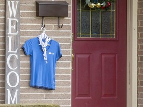A Girl Guide shirt hangs by the front door of a home in Oakridge to honour Alexandra Stemp, an eight-year-old Brownie who died in a crash last week, and other Brownies who were injured when an SUV struck a group of 10 people walking along Riverside Drive. Girl Guide leaders and the city are encouraging Londoners to display something blue, a colour associated with the Girl Guides, at their homes as a tribute to the victims to show support for them and their families. (Mike Hensen/The London Free Press)
