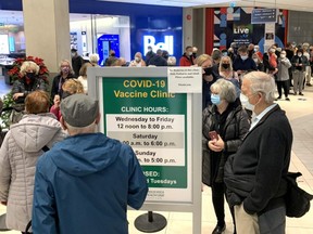 With appointments hard to come by to get a COVID-19 booster shot at mass vaccination clinics in the London area, people line up Wednesday to get a shot at a pop-up clinic at Masonville Place operated by the Middlesex-London Health Unit. Alex Summers, acting medical officer of health for Middlesex-London, said more appointments are being added at the mass vaccination clinics. He urges people over the age of 50 to book their booster shots before Monday when all Ontarians over the age of 50 can begin booking them. Photograph taken Wednesday Dec. 15, 2021. (Mike Hensen/The London Free Press)