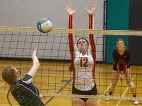 Brook Chaplin of the Laurier Rams hits past the block of Olivia Moffat of the Saunders Sabres during their match Thursday, Dec. 16, 2021, at Laurier secondary school. It was the second game for both senior girls' teams in the Thames Valley Central division. (Mike Hensen/The London Free Press)
