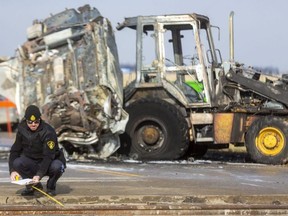 An Ontario Provincial Police officer takes measurements at the scene of a fatal collision on Dundonald Road near Glencoe on Tuesday Dec. 21, 2021. A northbound car appears to have crashed through a road-closed barricade and struck an empty backhoe at a construction site. Mike Hensen/The London Free Press/Postmedia Network