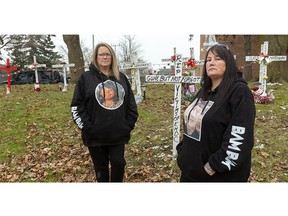 Tanya Welch, first wife of Floyd Deleary, and Dar Maynard, mother of Brandon Marchant, who both died while inmates at Elgin-Middlesex Detention Centre, stand in front of crosses honouring all the inmates who've died at the jail over the past decade-plus. They were removed from the jail's entrance but are now nearby, on private property. (Mike Hensen/The London Free Press)