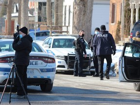 A London police forensic investigator takes photos on Springbank Drive where police found a man with suspected stab wounds just before noon on Monday.  The man died in hospital.  No arrests have been made.  Photo taken Monday Jan.  31, 2022. DALE CARRUTHERS / THE LONDON FREE PRESS