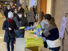 People pick up rapid antigen test kits at the Place d’Orléans shopping centre in Ottawa on Monday, Jan. 3, 2022. Free test kits will be handed out at Masonville Place in London on Thursday and Friday. (ERROL MCGIHON, Postmedia Network)