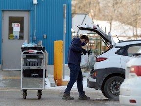 A personal shopper loads groceries into the back of a vehicle at a grocery store in Winnipeg on Nov. 23, 2020.