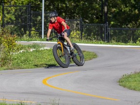 A cyclist leans into a curve while cruising on the Thames Valley Parkway at Ross Park in London on Sept. 19, 2021.  An extension of the parkway in the SoHo neighbourhood is one of seven proposed upgrades for which the city is expected to seek funding from the federal and provincial governments.  (Derek Ruttan/The London Free Press)