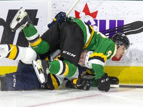 Landon Sim of the London Knights body checks Artyom Kulakov of the Erie Otters into the boards in a game at Budweiser Gardens in London on Jan. 21, 2022. The Knights play the Saginaw Spirit Friday in the first of three games this weekend in Michigan. (Derek Ruttan/The London Free Press)