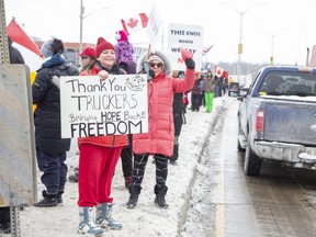 Hundreds people line Highbury Avenue and the centre median in front of the London Flying J truck stop at Wilton Grove Road in south London Thursday, Jan. 27, 2022, to show support for truck drivers in a convoy on the way to Ottawa to protest the cross-border vaccine mandate. (Derek Ruttan/The London Free Press)