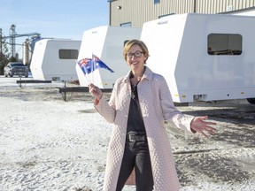 General Coach Canada procurement manager Heather Millar waves the flag of Australia, where  four of the company's custom-made trailers are going, to be used by the stars during filming of the upcoming Mad Max movie. It's the furthest distance General Coach has shipped its theatrical trailers. (Derek Ruttan/The London Free Press)
