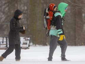 Lindsay and Matthew Smith head out for a snowy walk with their son Wyatt, 9 months old in Gibbons Park in London, Ont. Lindsay said they were out to get some fresh air and enjoy the snow. (Mike Hensen/The London Free Press)