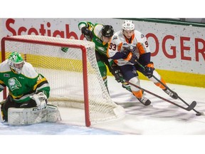 London Knights defenceman Logan Mailloux reaches to deny a wraparound attempt by Amadeus Lombardi of the Flint Firebirds during first-period Ontario Hockey League action at Budweiser Gardens Friday night. 
(Mike Hensen/The London Free Press)