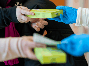 People pick up rapid antigen test kits at a mall in Ottawa on January 3, 2022. Ontario says it expects rapid test demand will increase to 18 million per week as the Omicron variant spreads.