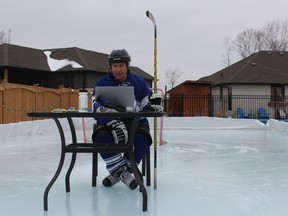 Lambton College professor Justin Randall said he wanted to try something different Wednesday for the first class of the winter semester. He wore full hockey gear and taught the virtual class with his lap top set up on a patio table on the backyard rink at his home in Corunna. (PAUL MORDEN, Postmedia Network)