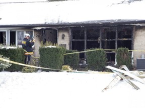 Clive Hubbard of the Ontario Fire Marshal's Office takes photos at a home at 1281 Hillcrest Ave. in London following a fire early Tuesday. The London fire department says 12 people escaped the home and another three were rescued by firefighters. The City of London is investigating the number of people living in the home. (Derek Ruttan/The London Free Press)