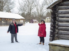Dawn Miskelly, left, executive director of Fanshawe Pioneer Village, and Christina Lord, a member of the London Black History Co-ordinating Committee, point to the proposed location of the Fugitive Slave Chapel between the village's log school house and blacksmith shop. A campaign launched Tuesday to raise $300,000 to move the chapel from its current location on Grey Street to the pioneer village. (Derek Ruttan/The London Free Press)