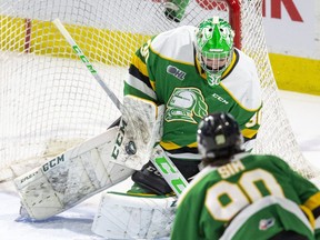 London Knight goalie Brett Brochu makes a blocker save in front of teammate Landon Sim in a game against the Windsor Spitfires at Budweiser Gardens in London on Feb. 4, 2022. (Derek Ruttan/The London Free Press)