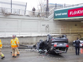 Wellington Street south of York Street in London was closed after an SUV drove through two fences and over a wall before plunging several metres to the road and landing on its roof. (Derek Ruttan/The London Free Press)