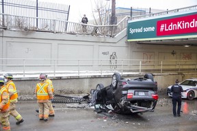 Wellington Street south of York Street in London was closed after an SUV drove through two fences and over a wall before plunging several metres to the road and landing on its roof. (Derek Ruttan/The London Free Press)