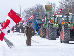 A man paces up and down the line of 18 farm vehicles parked on Highway 402 at the Forest Road exit in Lambton County on Sunday February 13, 2022. The six-day blockade ended peacefully one day later. Derek Ruttan/The London Free Press