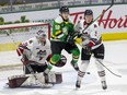 London Knights forward Colton Smith jumps out the way of a point shot while screening Guelph Storm goalie Owen Bennett and battling defenceman Ashton Reesor during the first period of their game at Budweiser Gardens  in London on Wednesday February 16, 2022. London won,  4-2. (Derek Ruttan/The London Free Press)