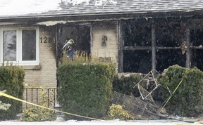 A fire investigator stands in the front door of a home at 1281 Hillcrest Ave.  that was damaged by a fire Feb.  1. Photograph taken Feb.  3, 2022. (Mike Hensen/The London Free Press)