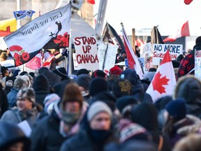 Protesters near Parliament Hill hold signs condemning vaccination mandates imposed by Prime Minister Justin Trudeau on February 5, 2022.